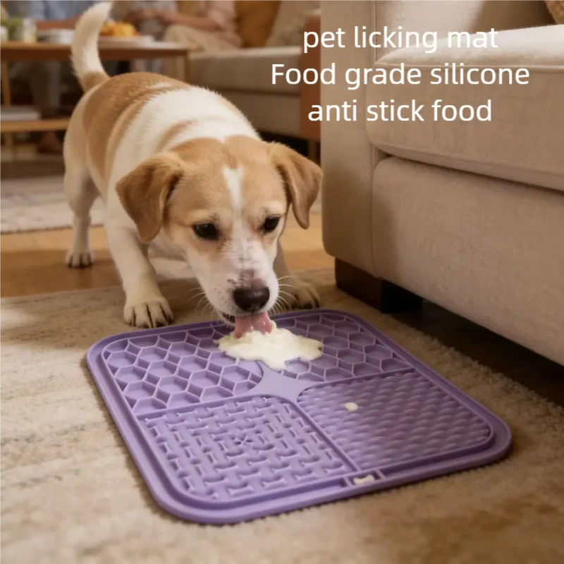 Chien léchant de la pâtée sur un tapis de léchage violet posé au sol